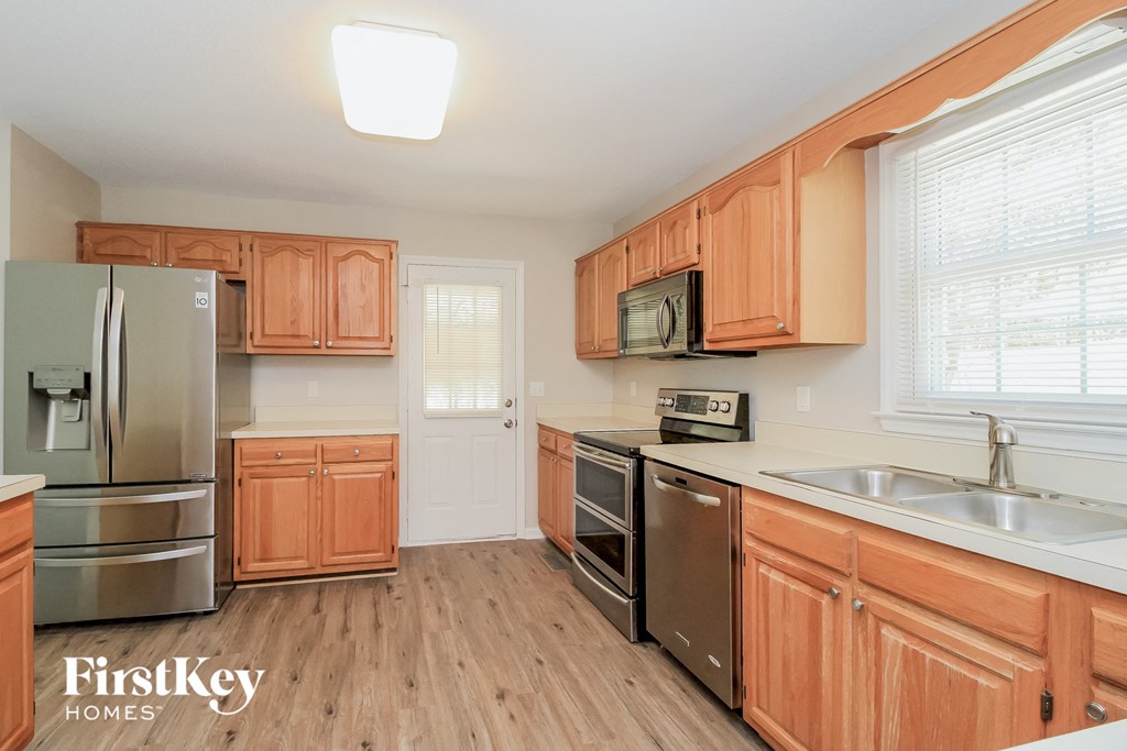 a kitchen with wooden cabinets and stainless steel appliances