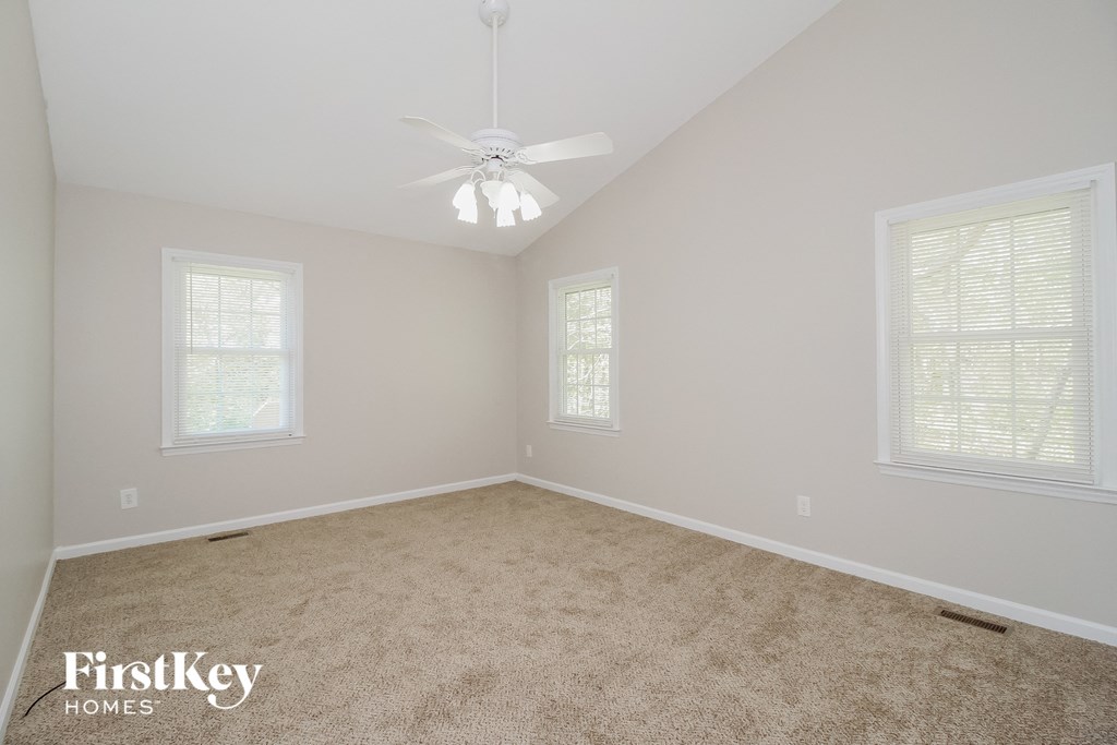 a bedroom with a carpeted floor and a ceiling fan