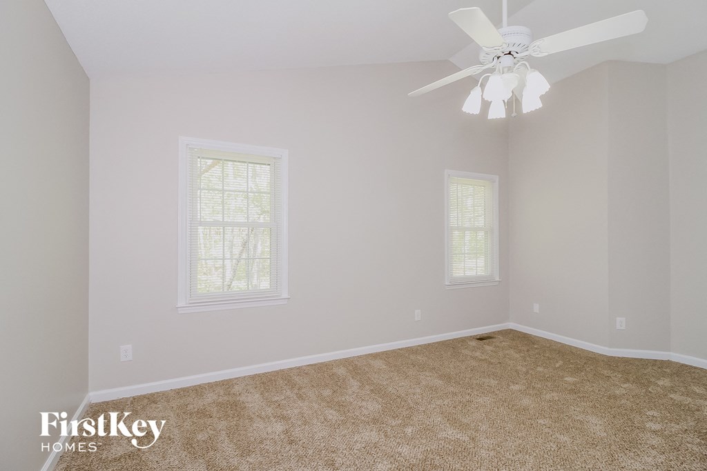 a bedroom with a ceiling fan and a carpeted floor
