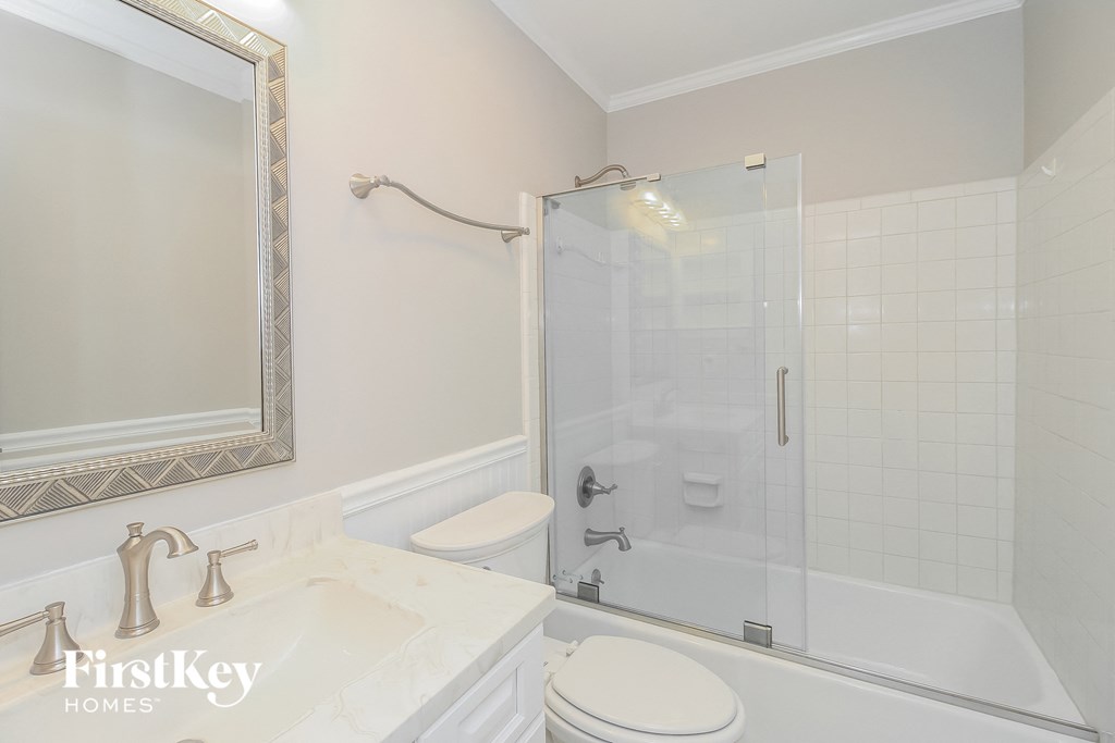 a white bathroom with a shower and a sink and a toilet