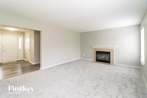 a living room with a fireplace and a white carpet