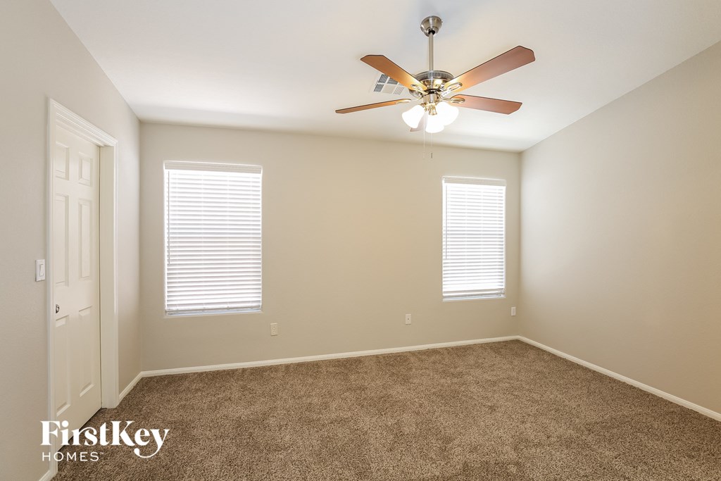 a bedroom with carpet and a ceiling fan