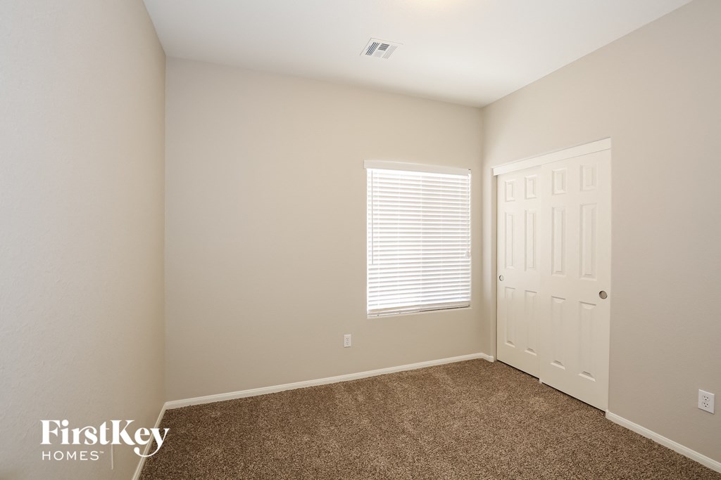 a bedroom with a carpeted floor and a white door