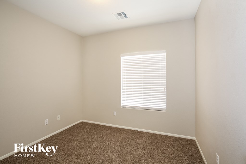 the upstairs bedroom has carpet and a window with white blinds