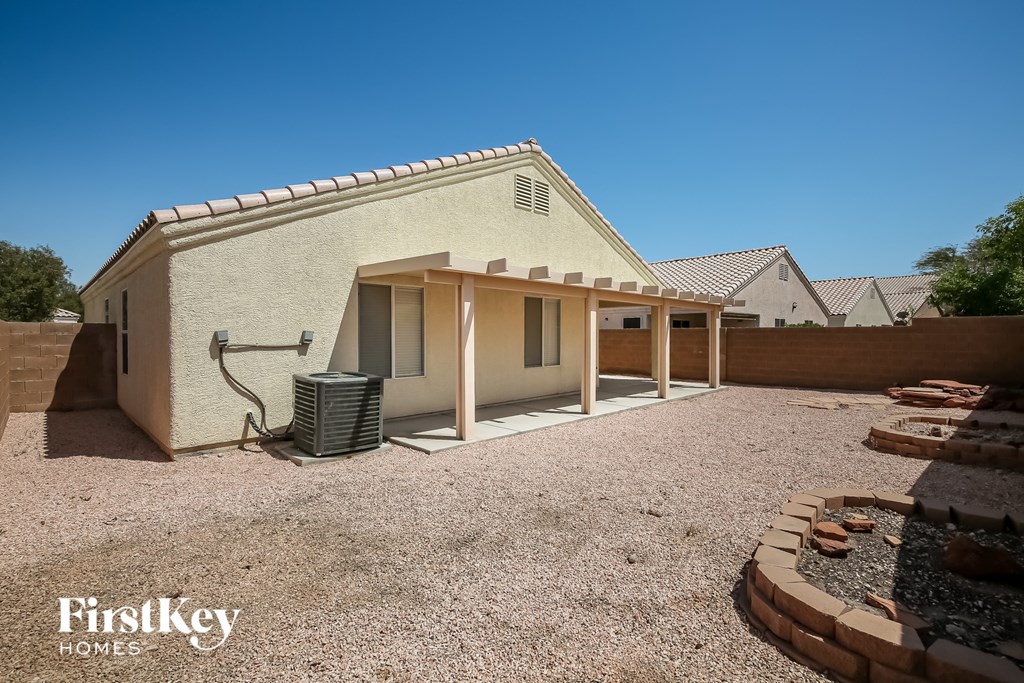 a small house with a dirt yard and a patio