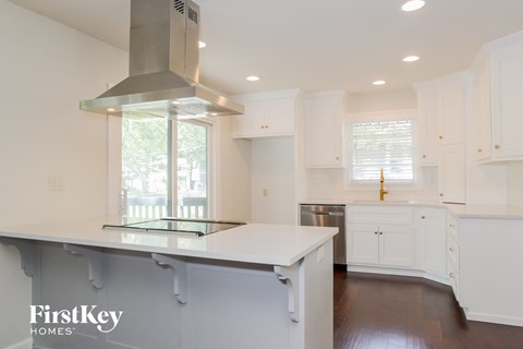 a white kitchen with a large island and white cabinets