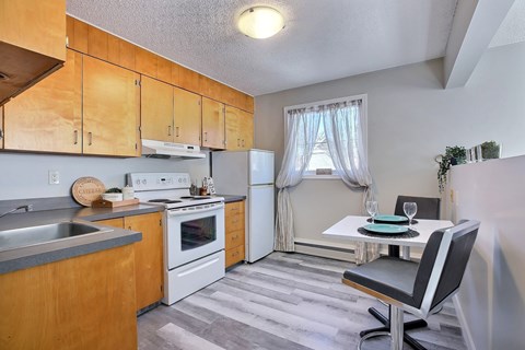 A kitchen with wooden cabinets and a white refrigerator.