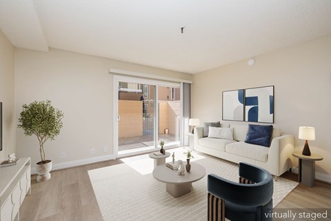 A living room with a white couch, a coffee table, and a painting on the wall.