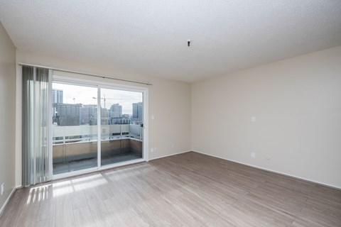 A large empty room with a view of the city through the window.