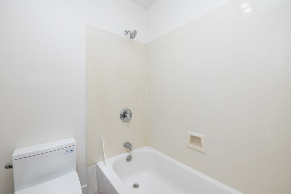 a bathroom with a tub and a toilet and a sink