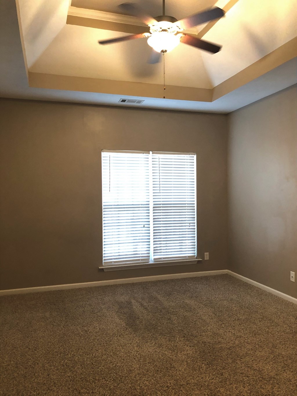 a living room with a ceiling fan and a window