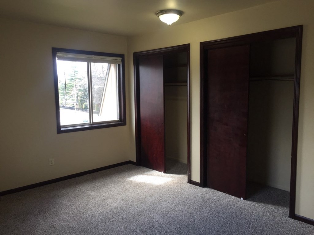 an empty room with two doors and a window