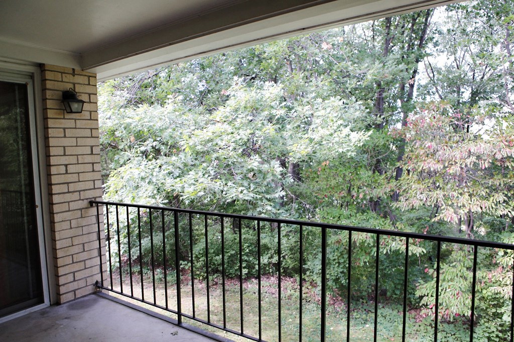 a balcony with a view of a yard and trees
