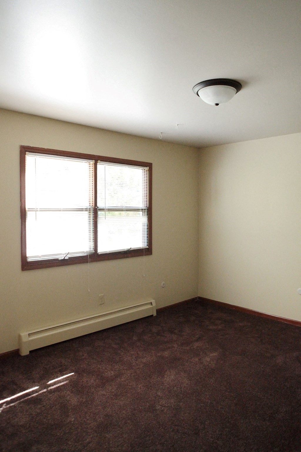 an empty room with a window and a carpet