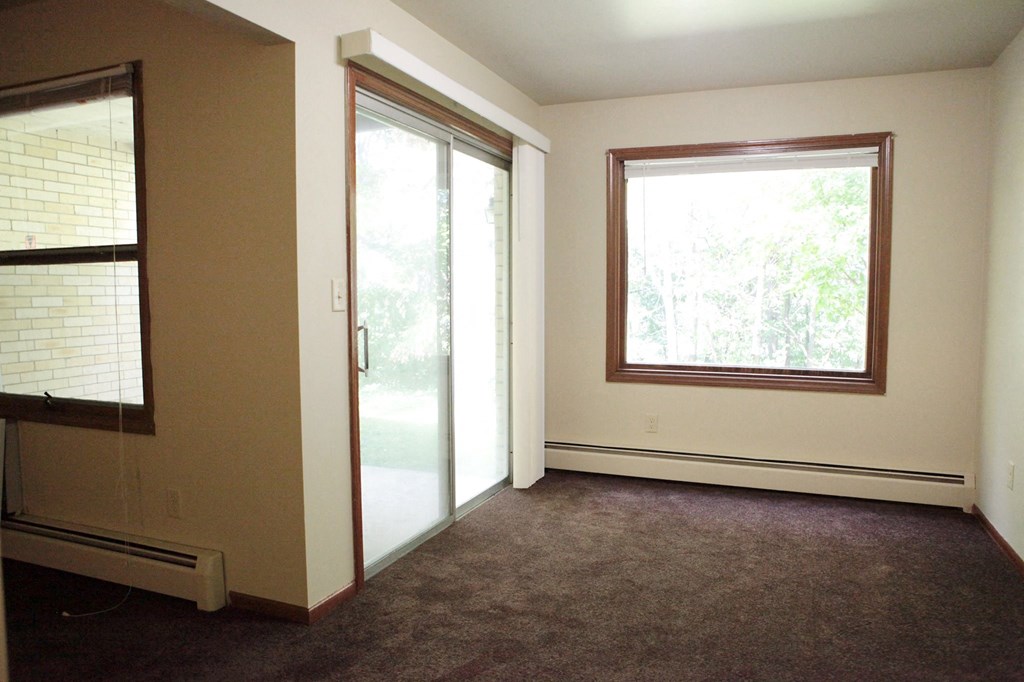an empty living room with a window and a door