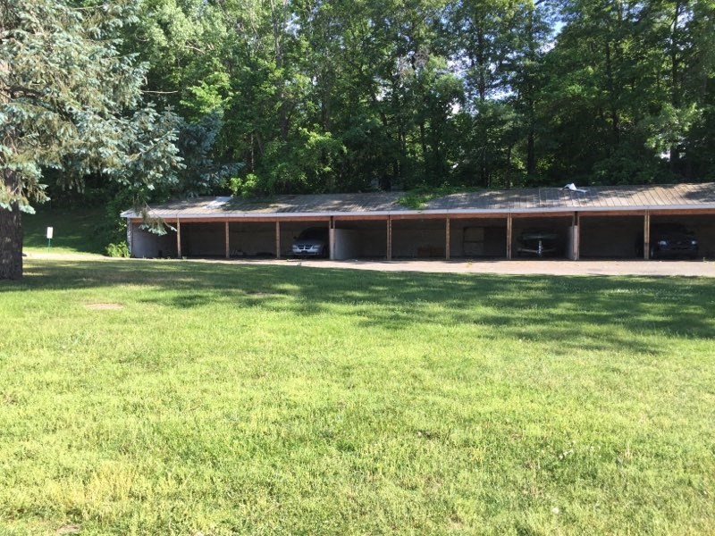 a building with a rusty roof in a grass field