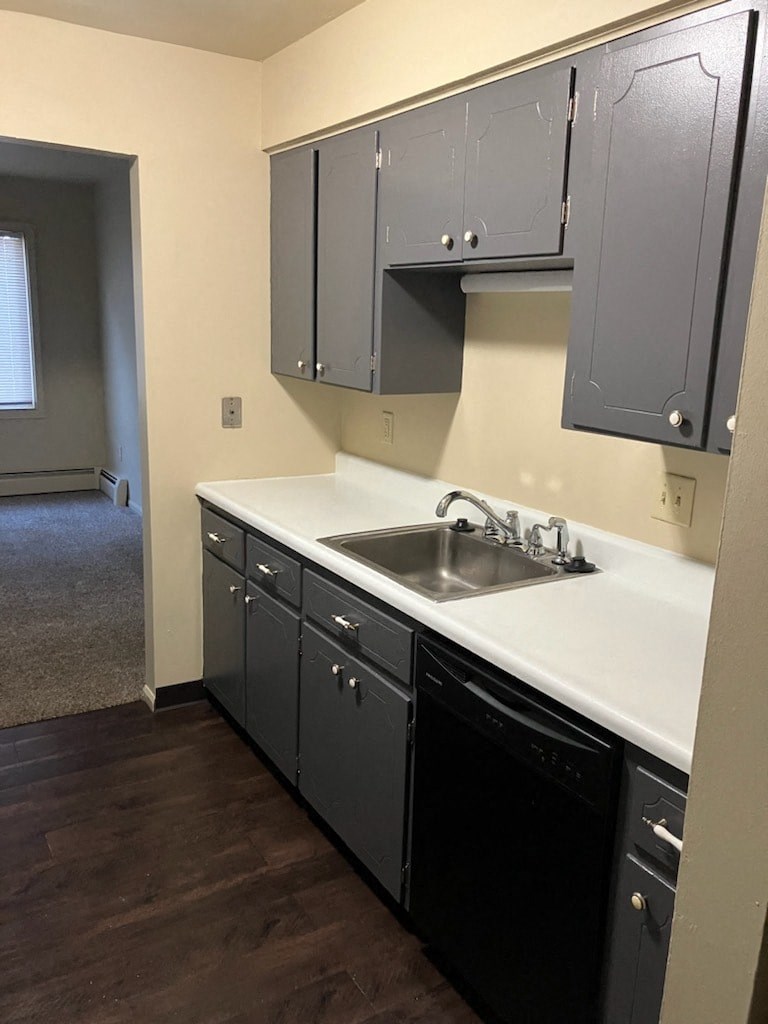 an empty kitchen with black cabinets and a sink