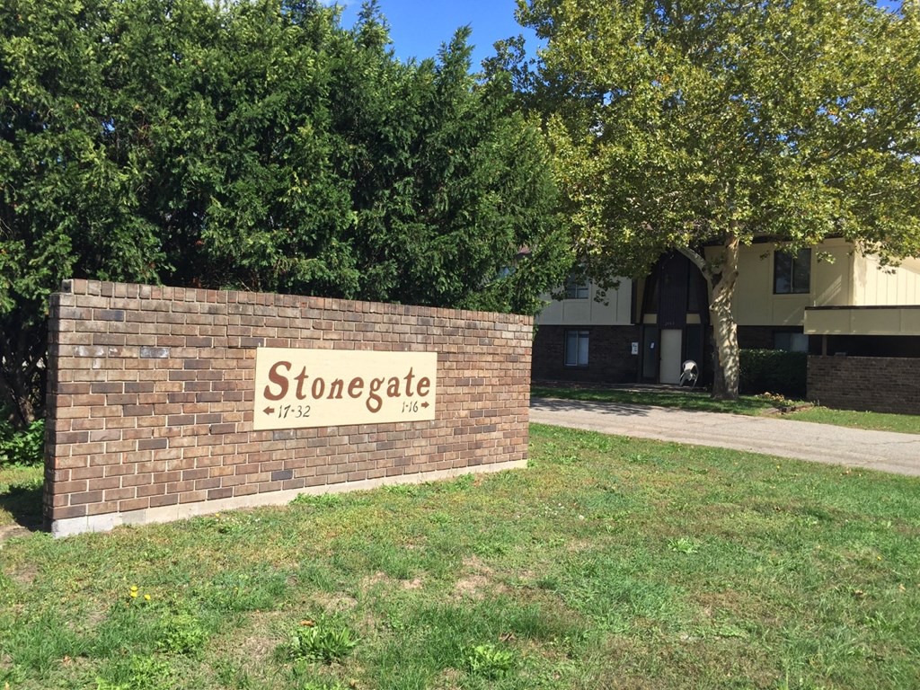 a brick wall with a stonegate sign in front of a building