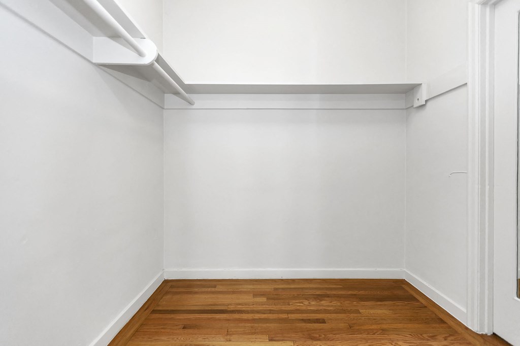 an empty room with white walls and a wooden floor