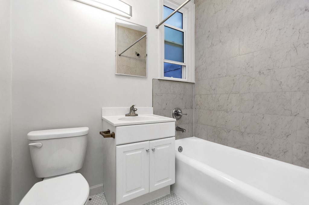 a white bathroom with a toilet sink and bath tub
