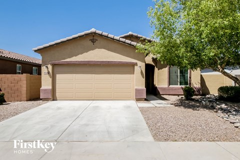 A house with a garage door and a tree in front.