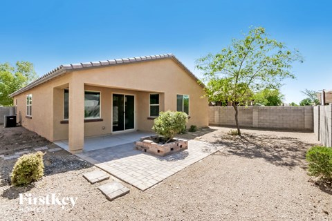 A house with a tan exterior and a gravel driveway.