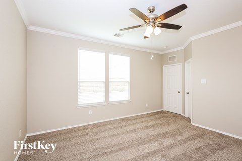 a bedroom with carpet and a ceiling fan