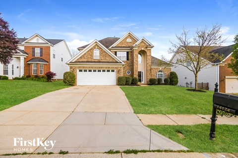 a house with a white garage door in front of a lawn