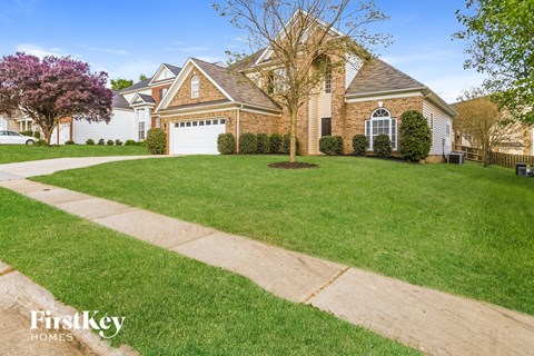 a home with a lawn and a sidewalk in front of it