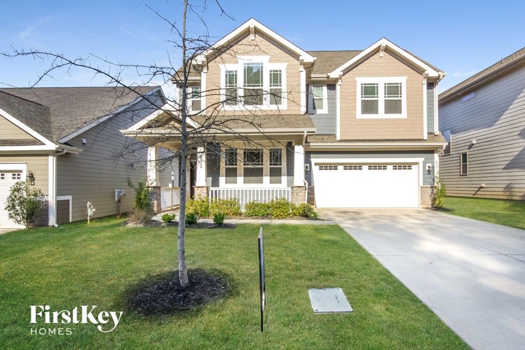 a home with a tree in the front yard