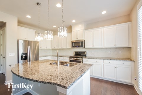 a large kitchen with white cabinets and granite counter tops