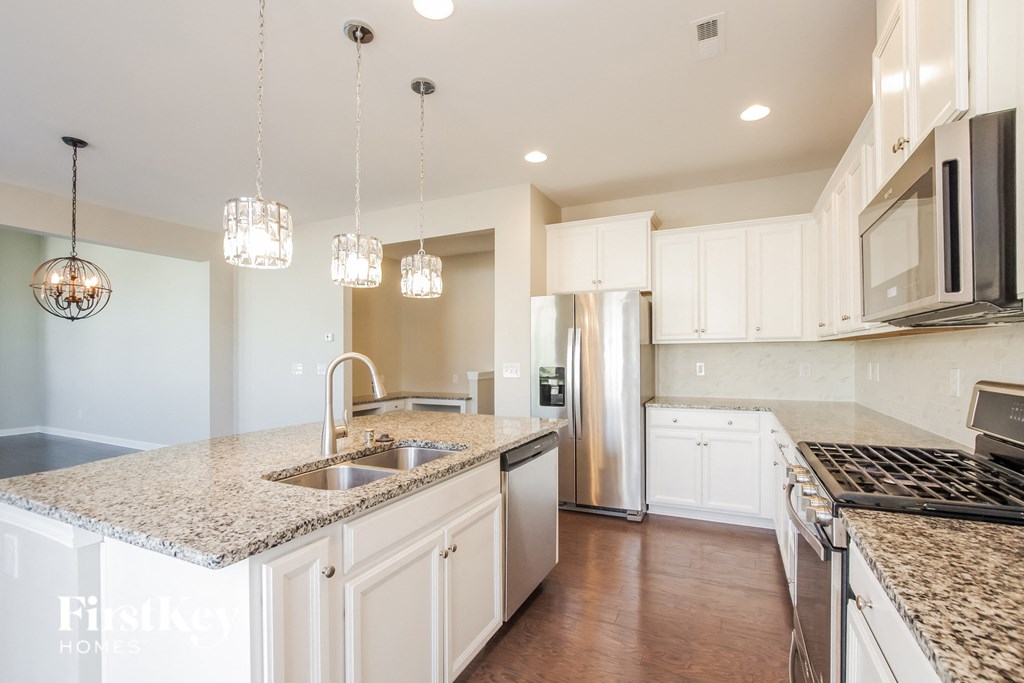 a kitchen with white cabinets and granite counter tops