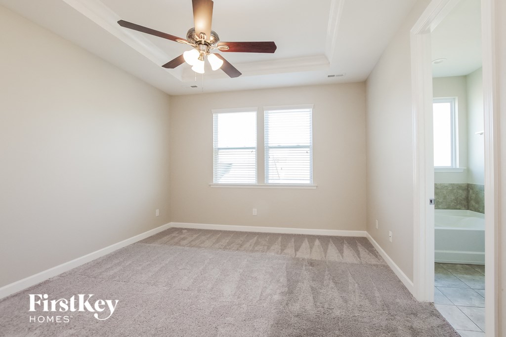 an empty room with a ceiling fan and a bathroom