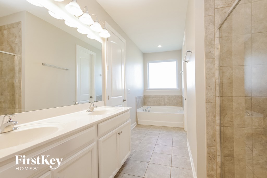 a white bathroom with a large mirror and a tub and a sink