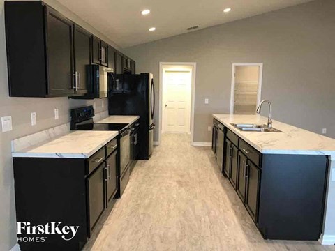 A kitchen with black cabinets and a white countertop.