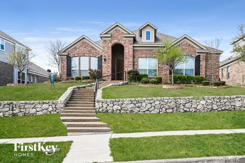 a home with a stone retaining wall and grass