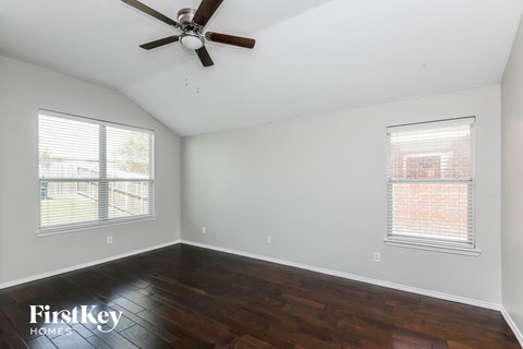 a living room with wood floors and a ceiling fan