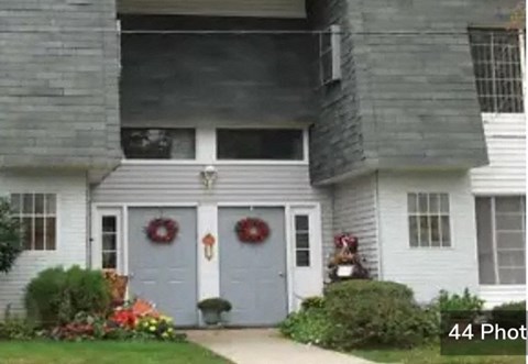 A house with a grey front door and two wreaths on the door.