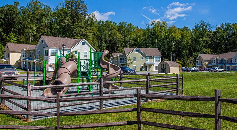 a playground with slides and houses in the background