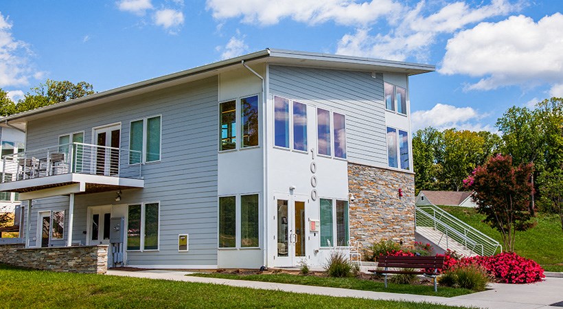 a blue house with a stone facade and a sidewalk