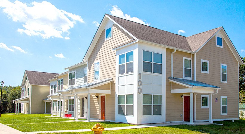 a row of houses with a fire hydrant in the grass