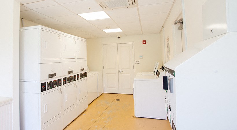 an empty kitchen with white appliances and white cabinets