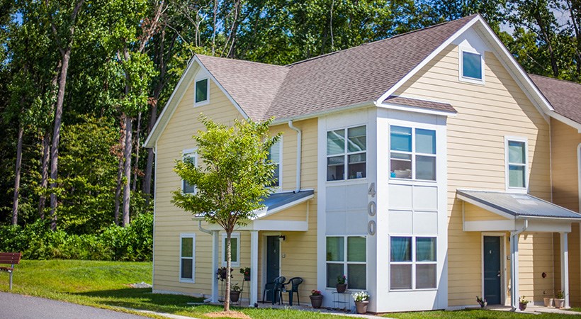 a yellow house with a tree in front of it