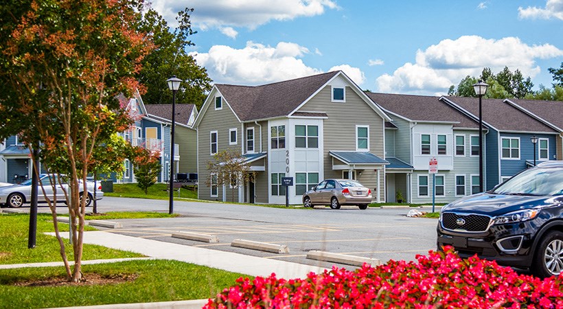a row of houses with cars parked in front of them