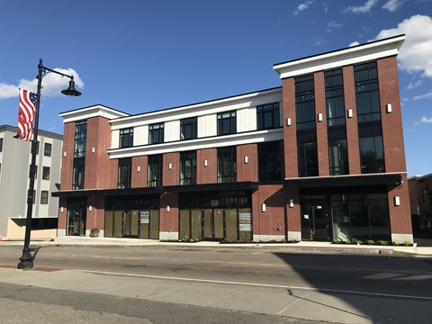 a red brick building with an flag on a street