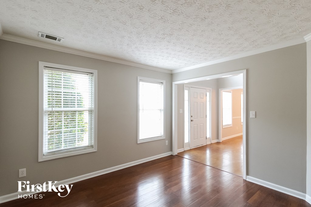 an empty living room with wood floors and a white ceiling