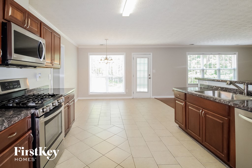 an empty kitchen with wood cabinets and stainless steel appliances