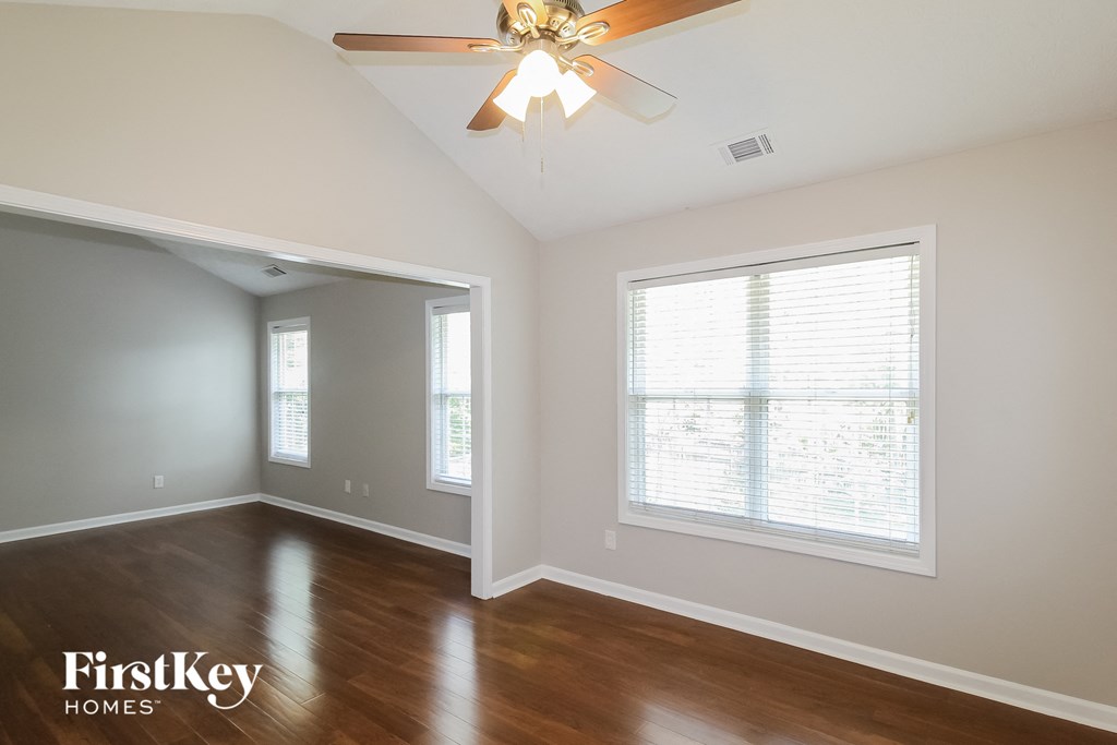 a living room with a ceiling fan and a large window