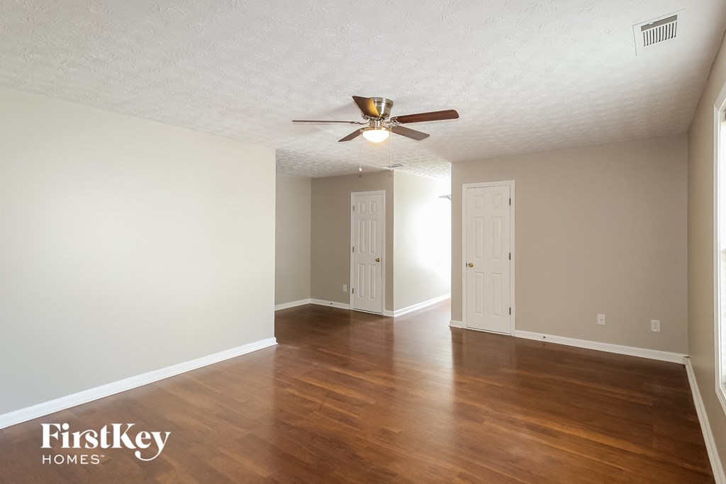 a living room with wood floors and a ceiling fan