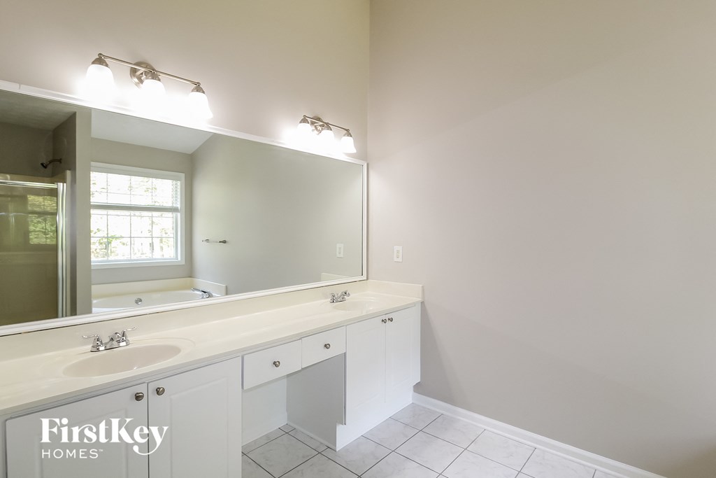 a white bathroom with a large mirror and a sink